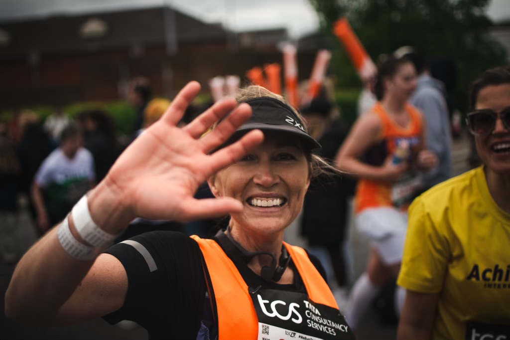 Cass Brownlow Davies at the London Marathon, smiling with hand to camera