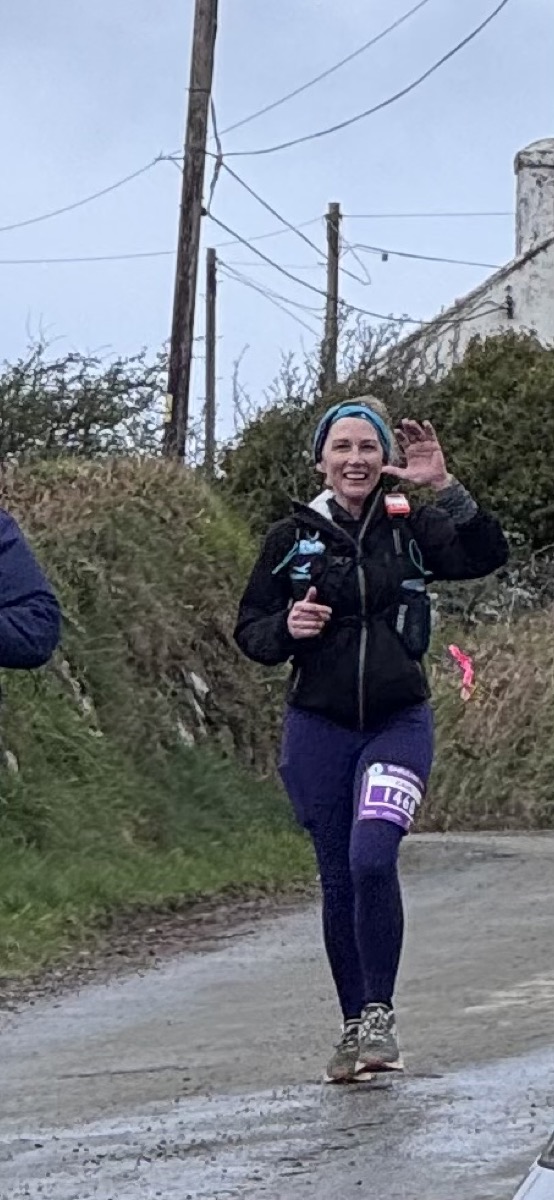 Cass running on a wet Welsh lane, waving to the camera