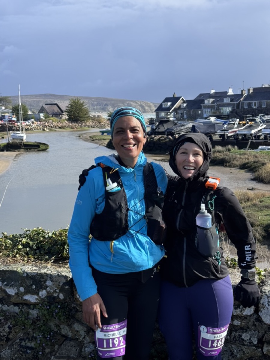 Cass (bib 1460) and Michelle (bib 1192) smiling at a Welsh harbour checkpoint